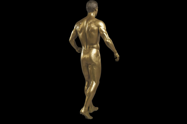 Gold statue of a nude male figure on a black background Cristiano Ronaldo Golden Doll